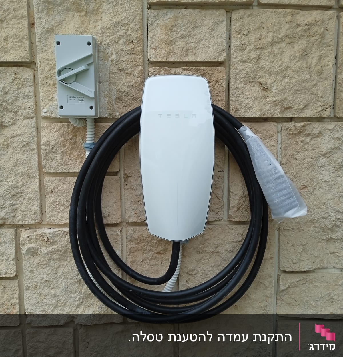 מטען טסלה מותקן על קיר עם כבל חשמל ארוך